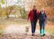 Couple walking the dog on a rural road