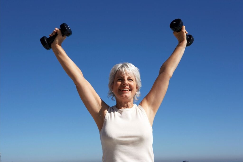 Woman with dumbbells outside