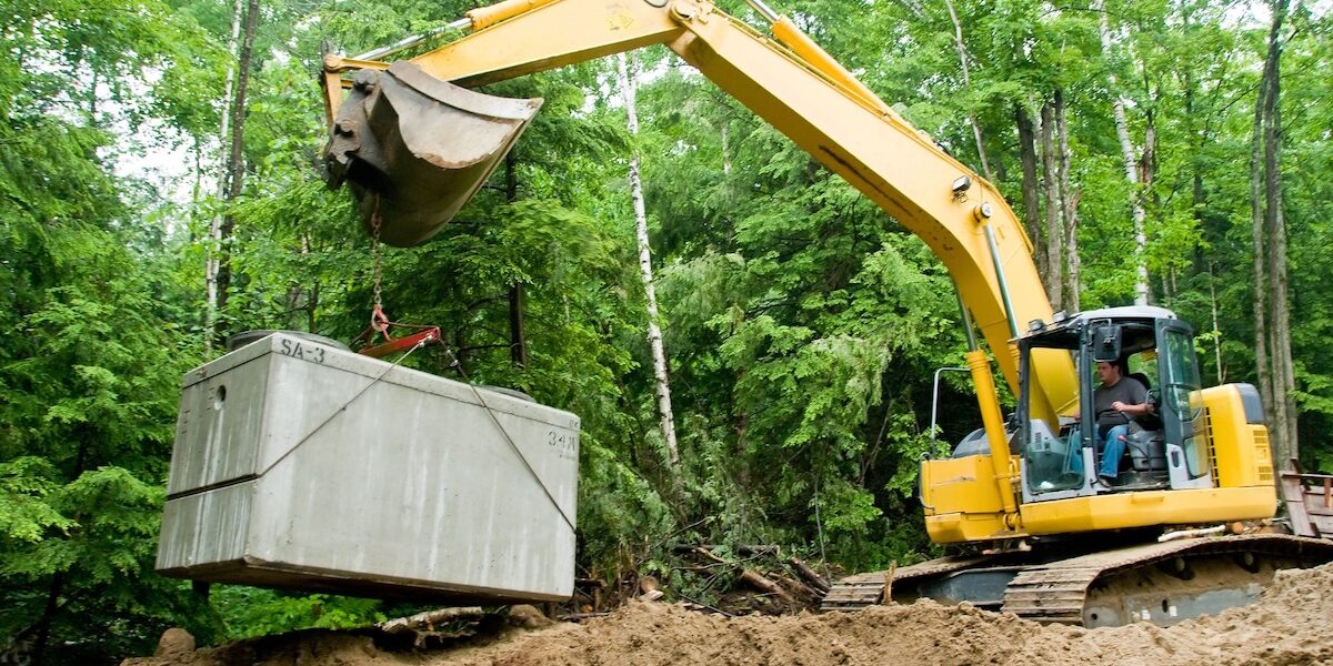 Septic system being put in place by backhoe