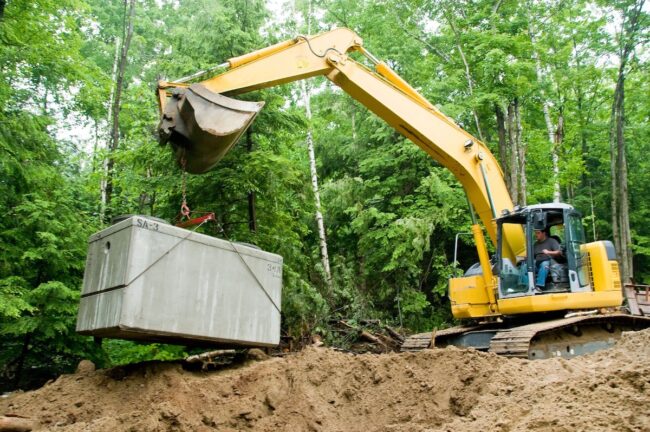 Septic system being put in place by backhoe